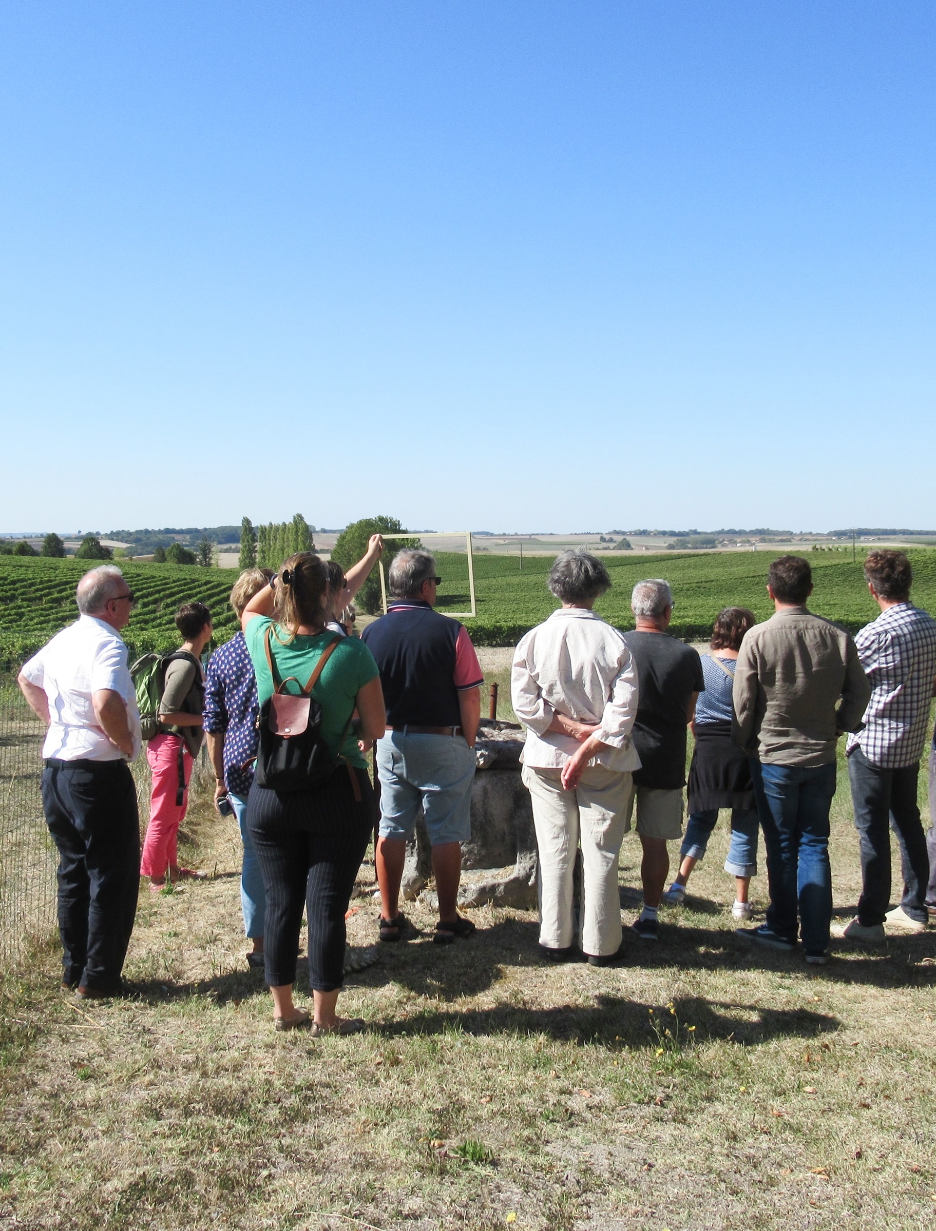 Groupe de participants lors d’une visite de terrain, observant un paysage agricole en Charente-Maritime.