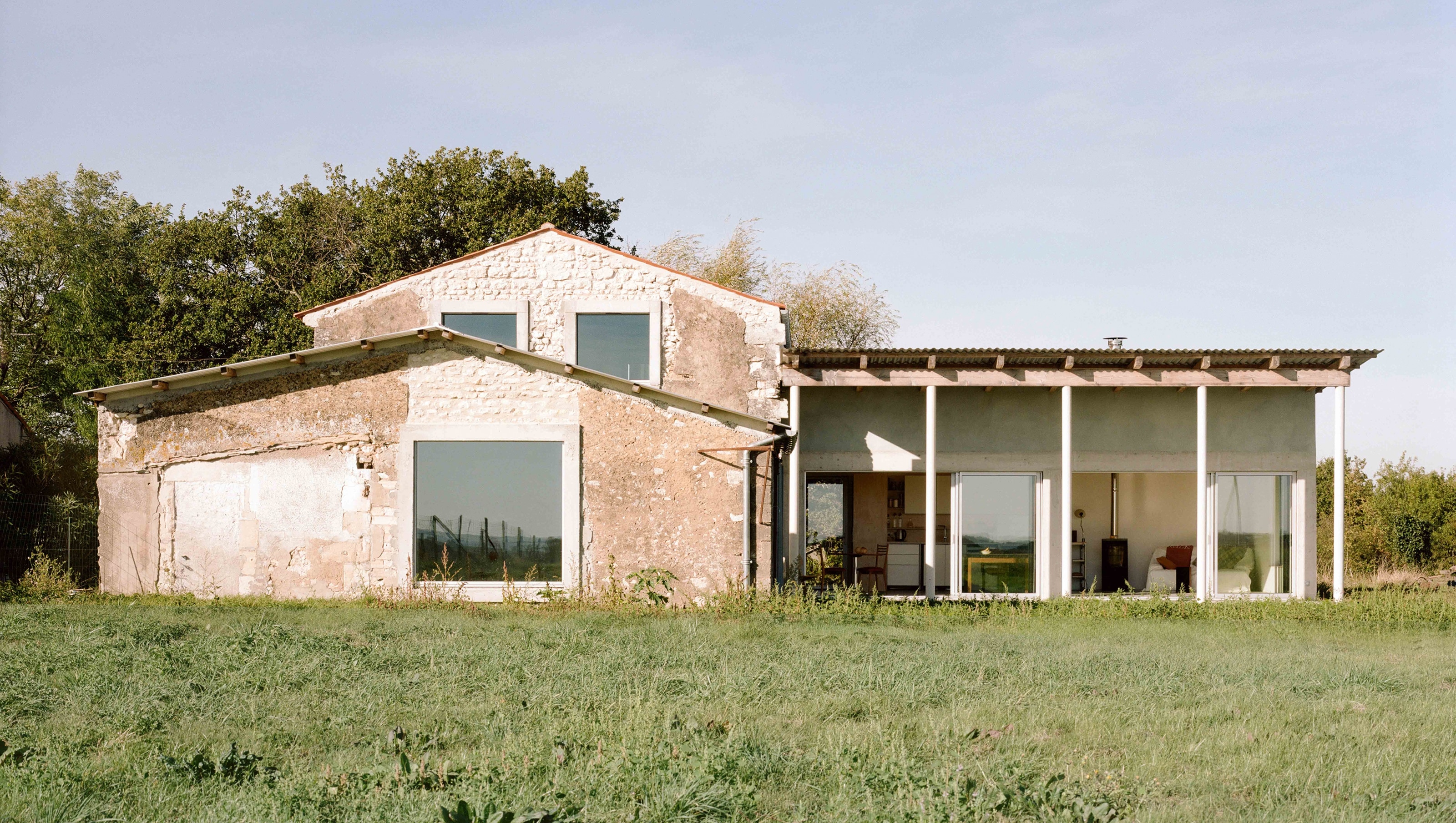 Grange en pierre réhabilitée et agrandie par une extension contemporaine en milieu rural.