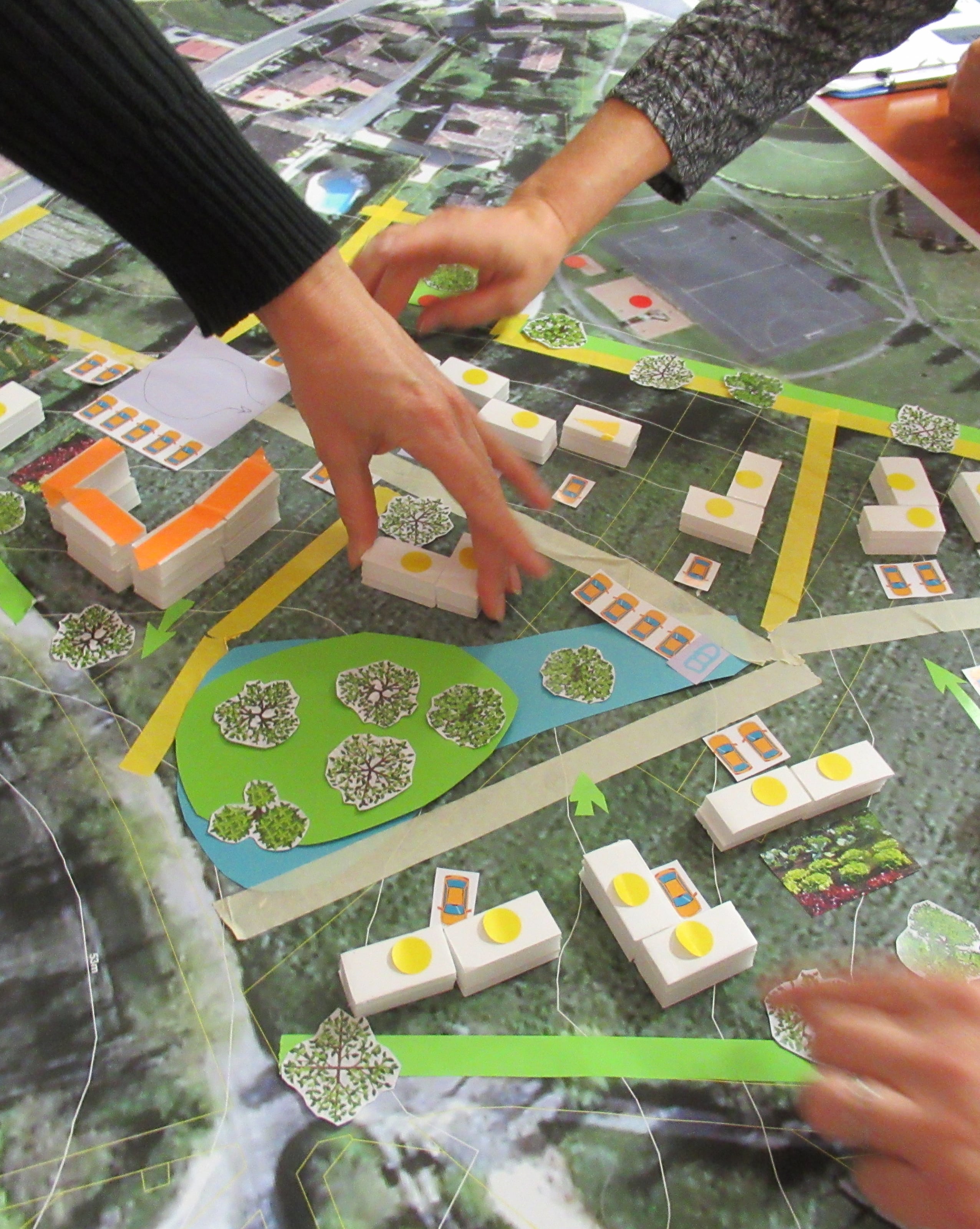 Atelier de travail avec les enfants autour d’une maquette et d’un plan pour réfléchir à un projet d’aménagement.