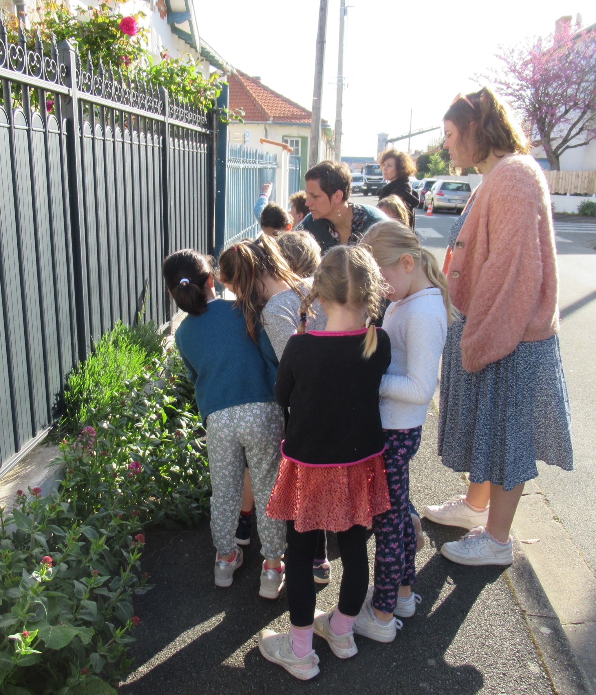 Atelier pédagogique avec des enfants, observant les plantations et l’espace public en milieu urbain.