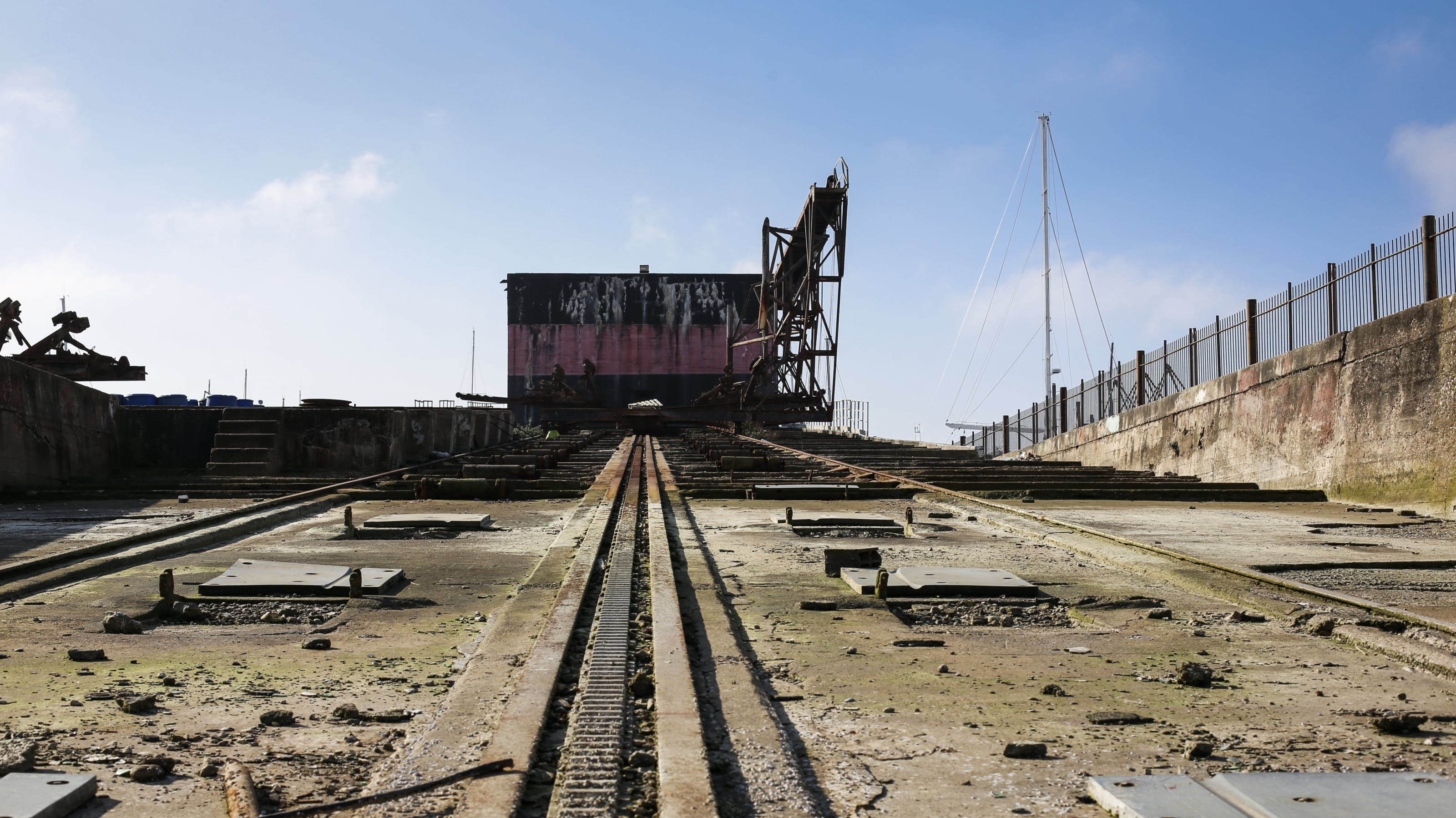 Ancien site industriel du quartier de La Pallice à La Rochelle, avec rails et infrastructure portuaire au premier plan.